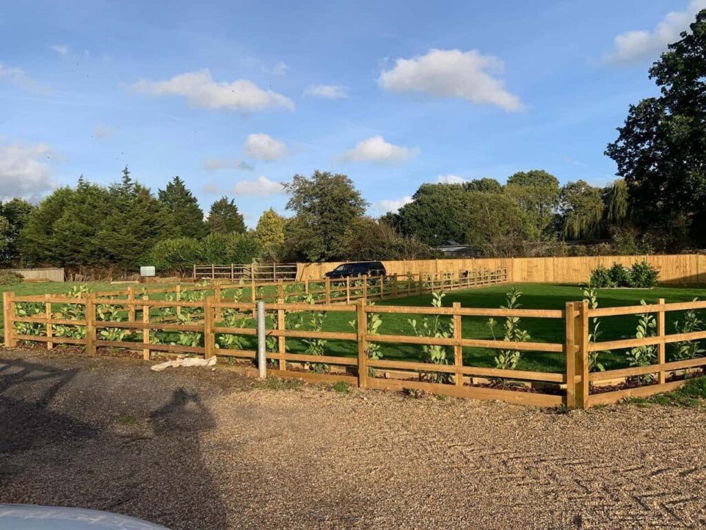 This is a photo of post and rail fencing with a gravel board installed at the base to create a flower bed, and at the rear is feather edge fencing along the edge of the garden. All works carried out by Fast Fix Fencing Impington